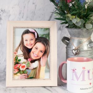 Mother and daughter photo in a picture frame next to a mug with mum on it