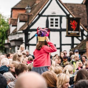 a girl sitting on ad adults shoulders in a crowd at Knowle jubilee celebrations