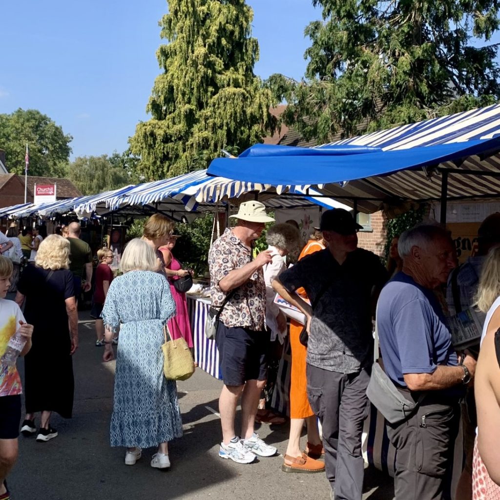 A busy market scene of people browsing market stalls in Knowle