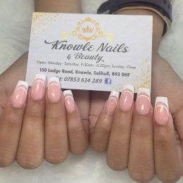Manicured hands are holding a business card for Knowle Nails and Beauty